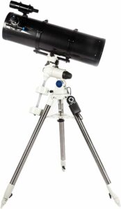 Telescopio rifrattore montato su treppiede contro sfondo stellato