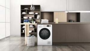 Asciugatrice Hotpoint Ariston a pompa di calore, modello NT M11 82K IT R, in una cucina moderna, con focus sulla sua capacità di 8 kg e le dimensioni compatte.